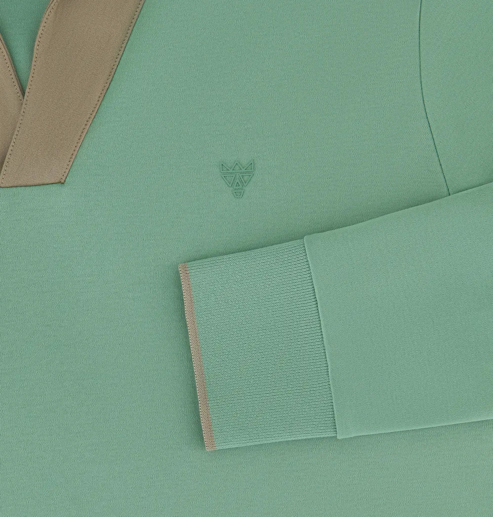 A long-sleeved green Doerkind polo shirt with a shawl collar and a small embossed emblem on the chest.